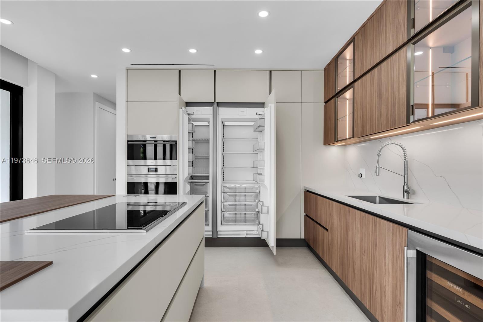 285 Woodcrest Road Key Biscayne, FL 33149 - Photo 24 of 53 a kitchen with stainless steel appliances kitchen island granite countertop a sink refrigerator and cabinets