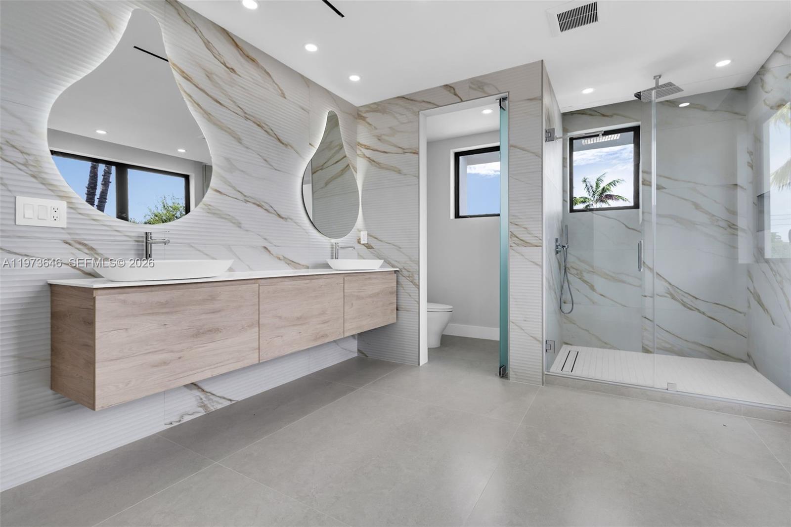 285 Woodcrest Road Key Biscayne, FL 33149 - Photo 27 of 53 a bathroom with a sink a vanity and mirror