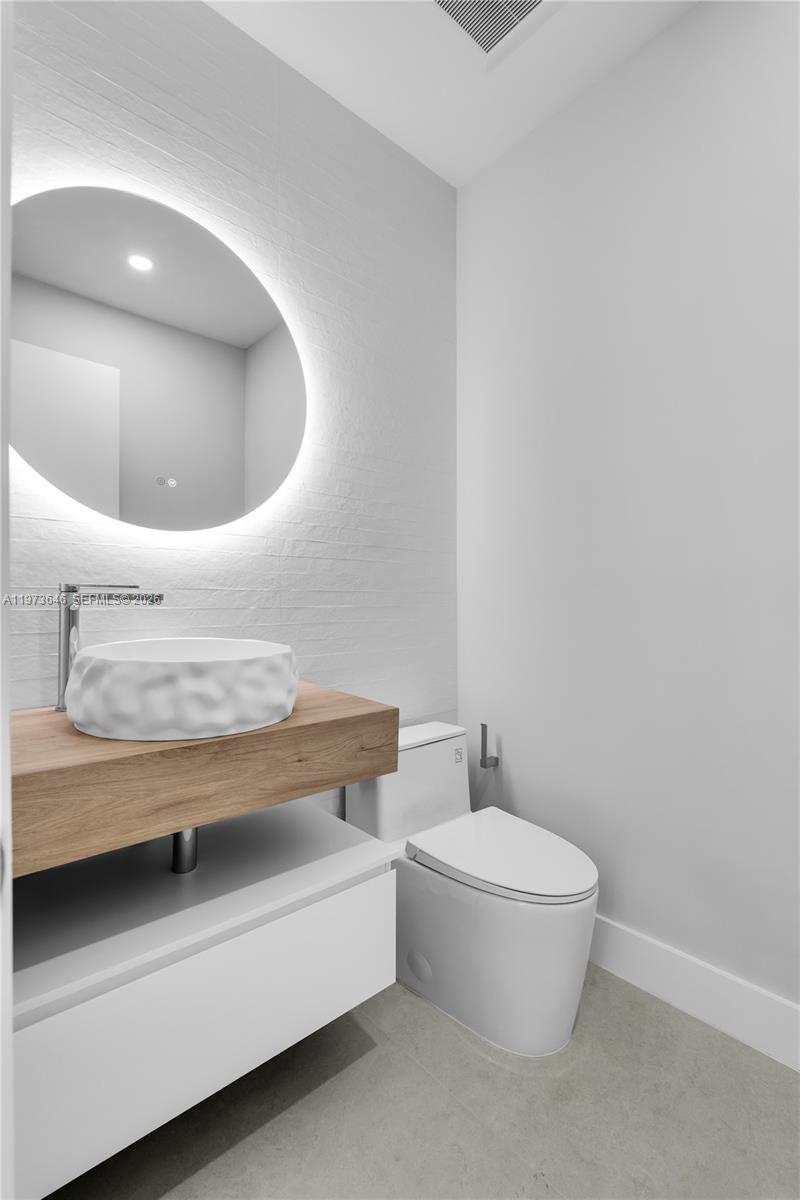 285 Woodcrest Road Key Biscayne, FL 33149 - Photo 36 of 53 a bathroom with a toilet and a mirror