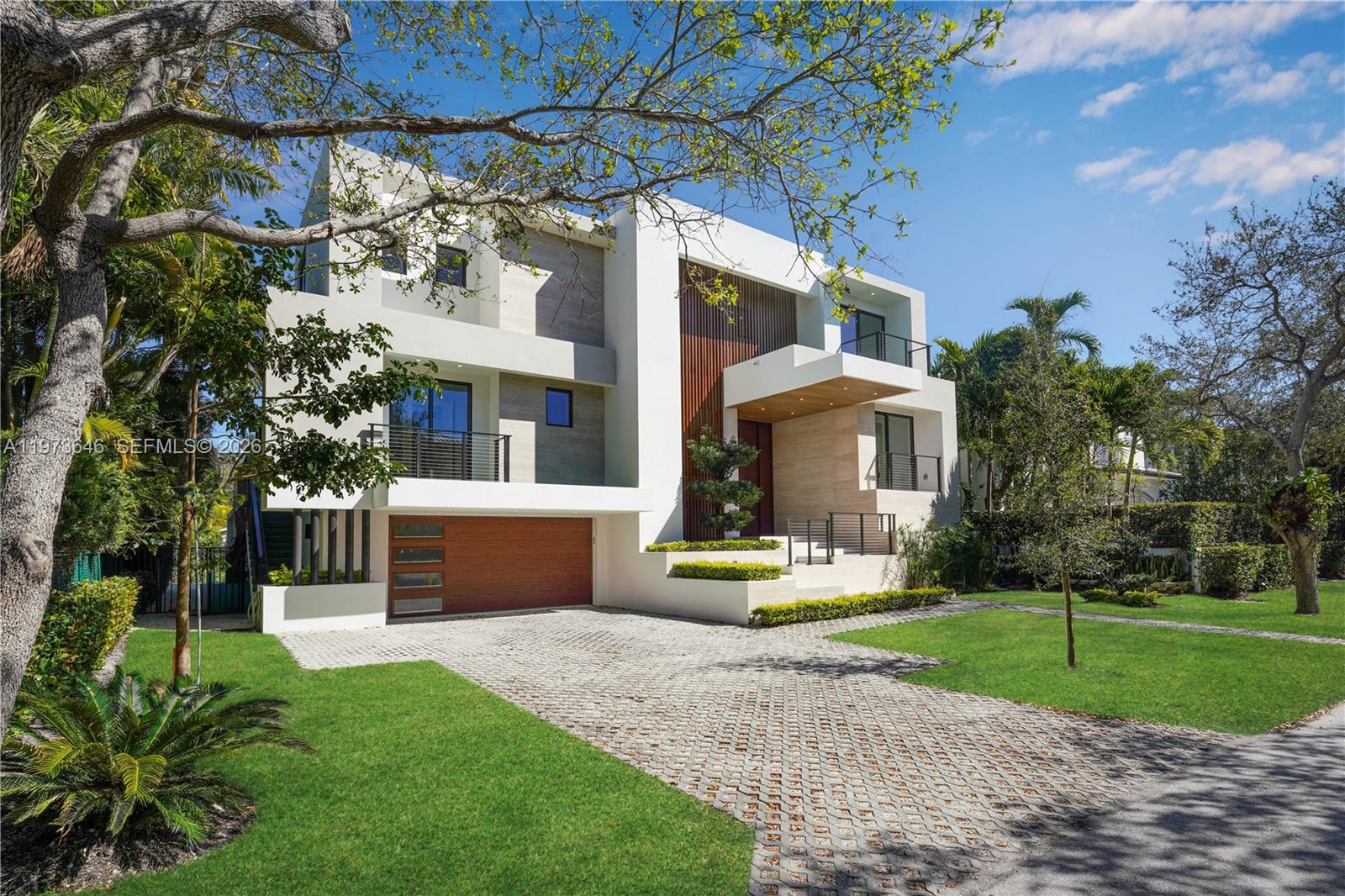 285 Woodcrest Road Key Biscayne, FL 33149 - Photo 4 of 53 a front view of a house with a yard and trees