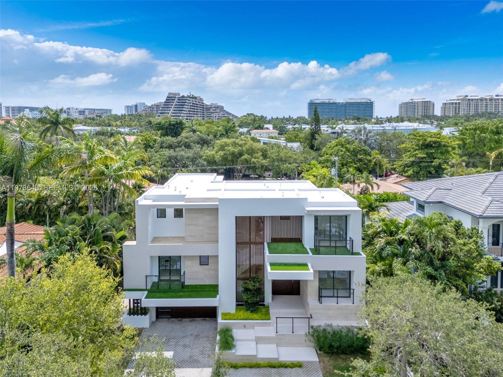 285 Woodcrest Road Key Biscayne, FL 33149 - Photo 49 of 53 a front view of a residential apartment building with a yard and potted plants