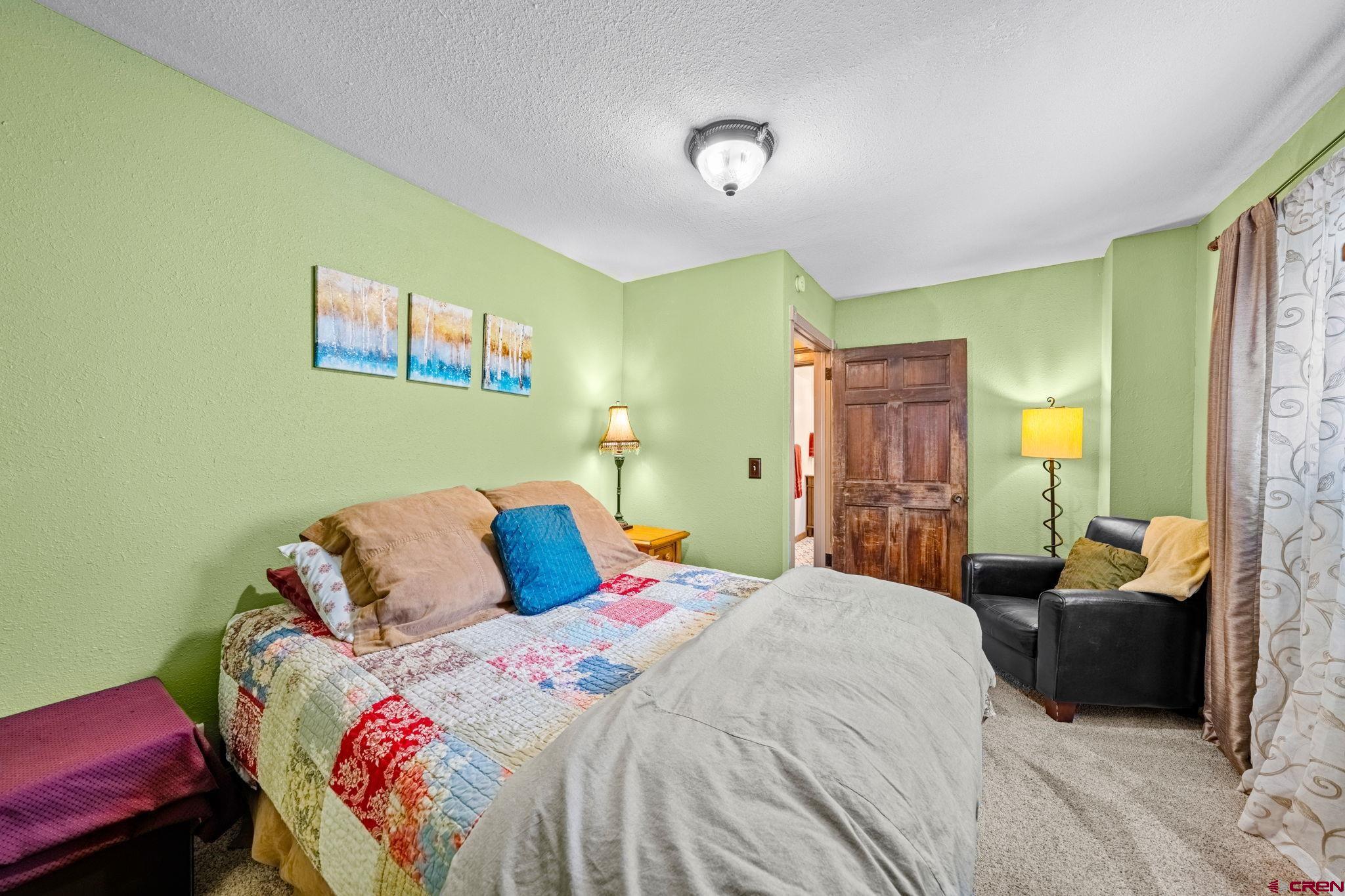 1257 Snowden Street Silverton, CO 81433 - Photo 19 of 29 a bedroom with a bed and wooden floor