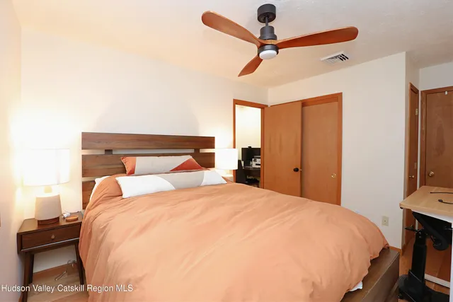 a bedroom with a bed and a tv on the dresser