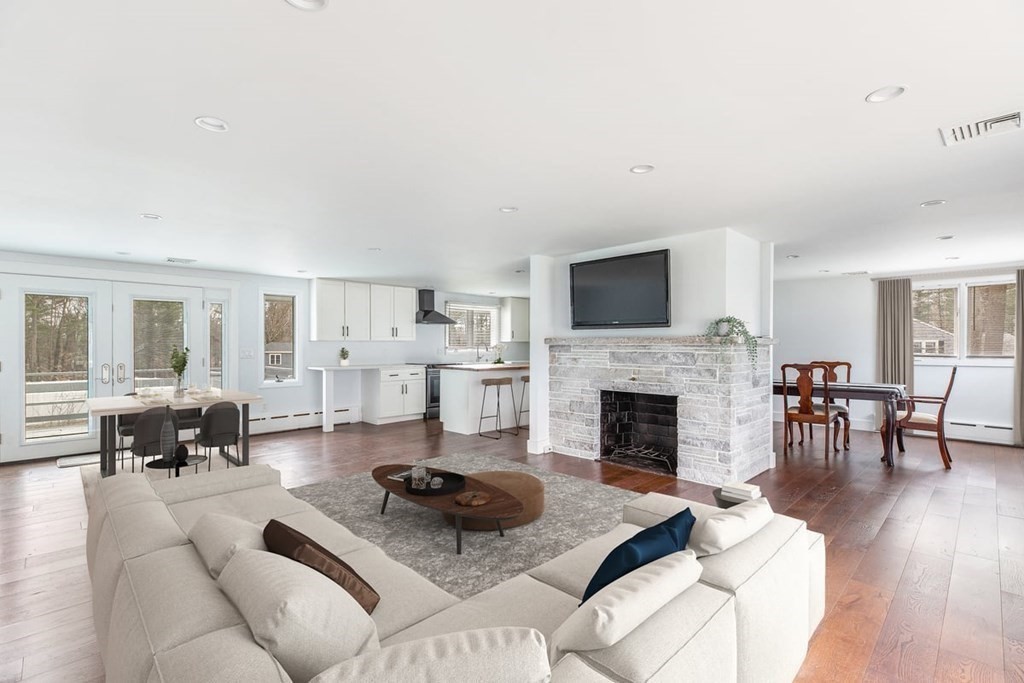 56 James Road Hanover, MA 02339 - Photo 2 of 31 a living room with furniture a fireplace and a dining table with wooden floor