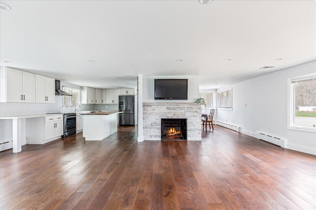 56 James Road Hanover, MA 02339 - Photo 5 of 31 a living room with stainless steel appliances wooden floor and a fireplace