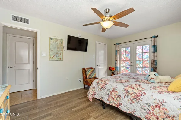 a bedroom with a bed a window and a flat screen tv