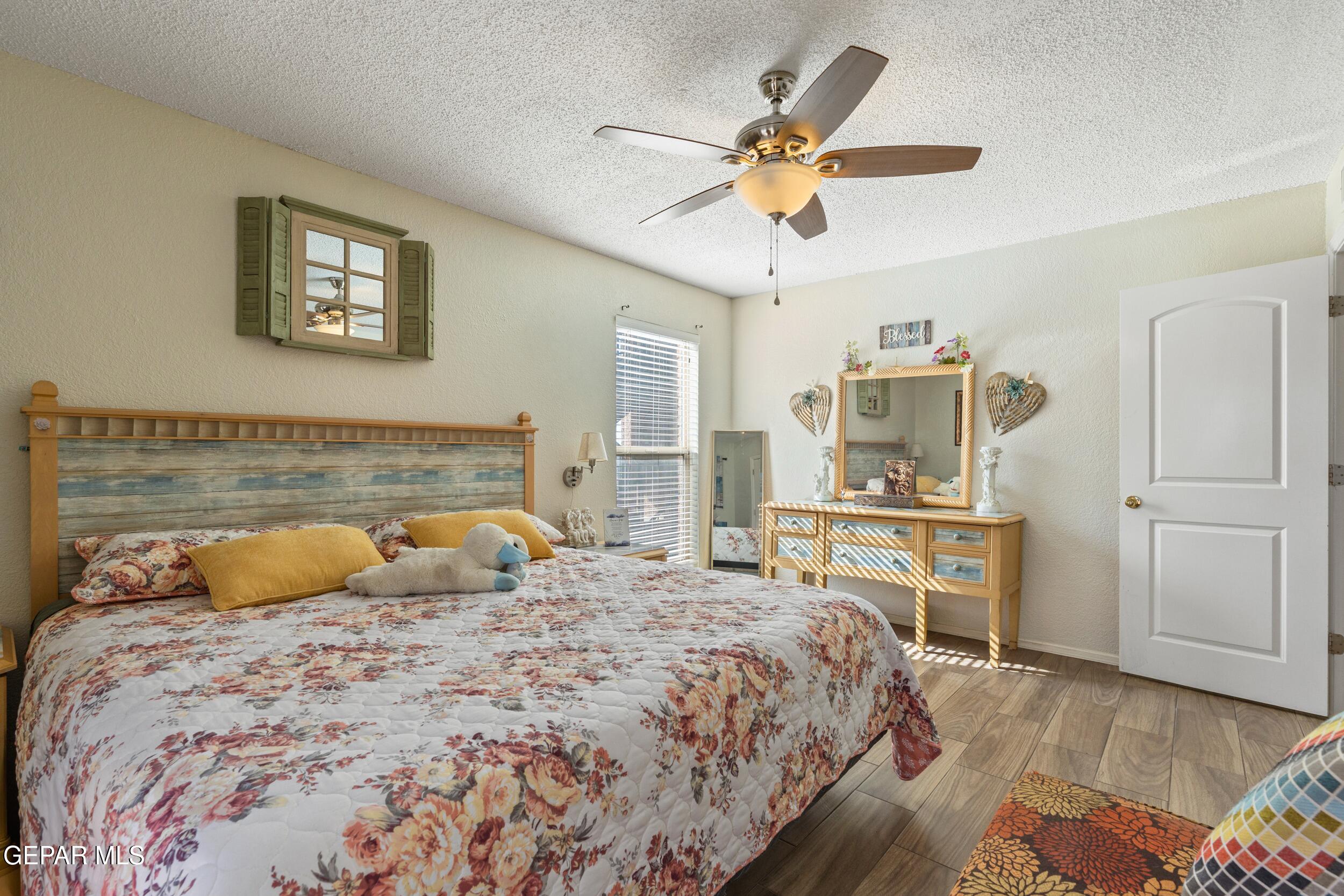 4433 North Stanton Street, Unit P358 El Paso, TX 79912 - Photo 13 of 19 a bedroom with a large bed and a chandelier