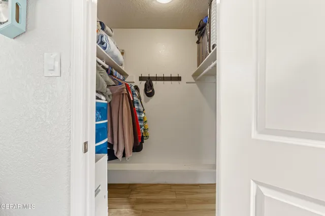 a view of walk in closet with clothes