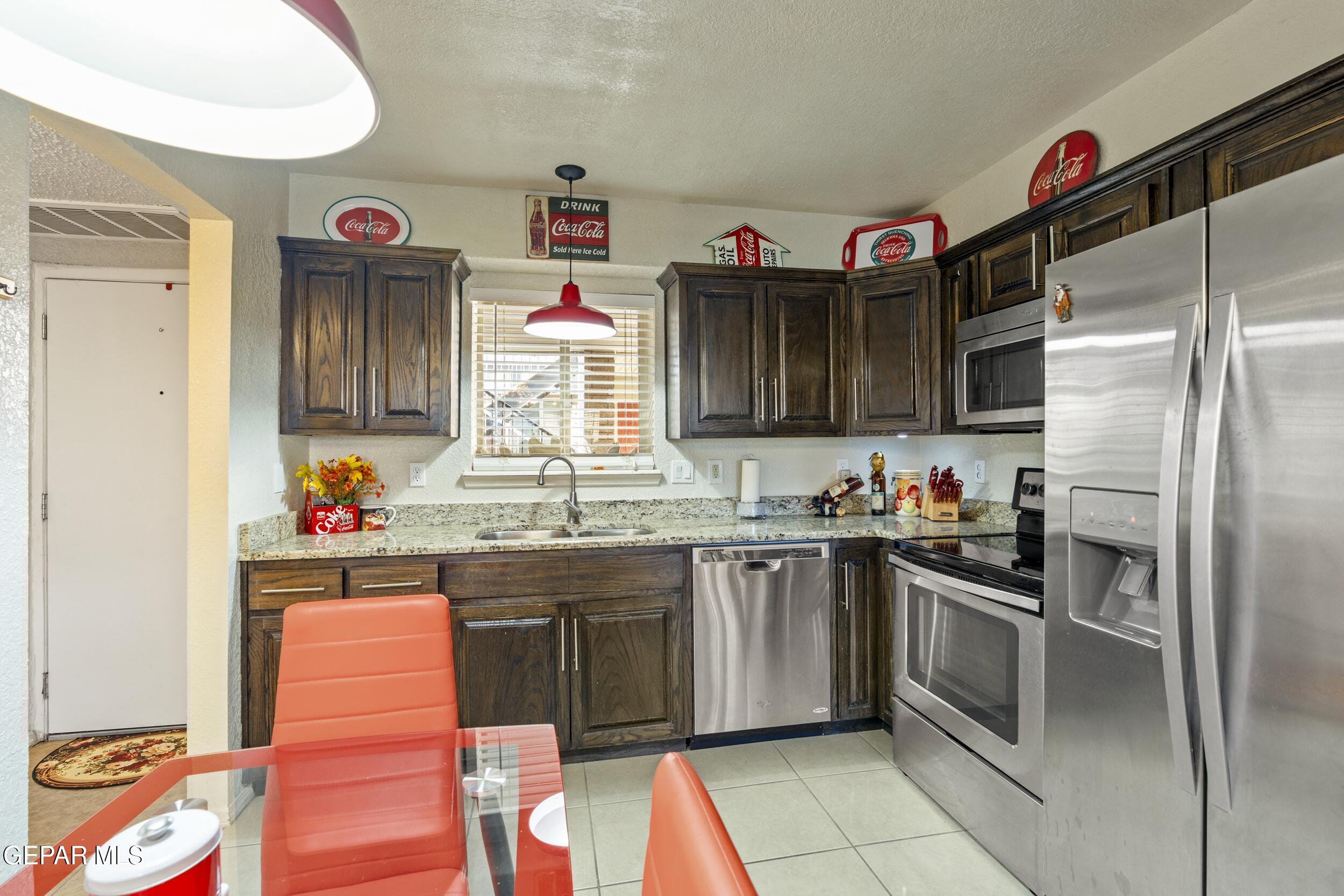 4433 North Stanton Street, Unit P358 El Paso, TX 79912 - Photo 3 of 19 a kitchen with granite countertop stainless steel appliances a sink and a refrigerator