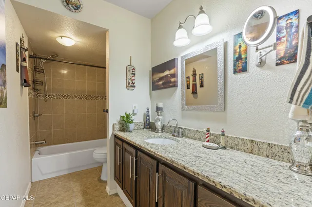 a bathroom with a granite countertop sink mirror and a bath tub