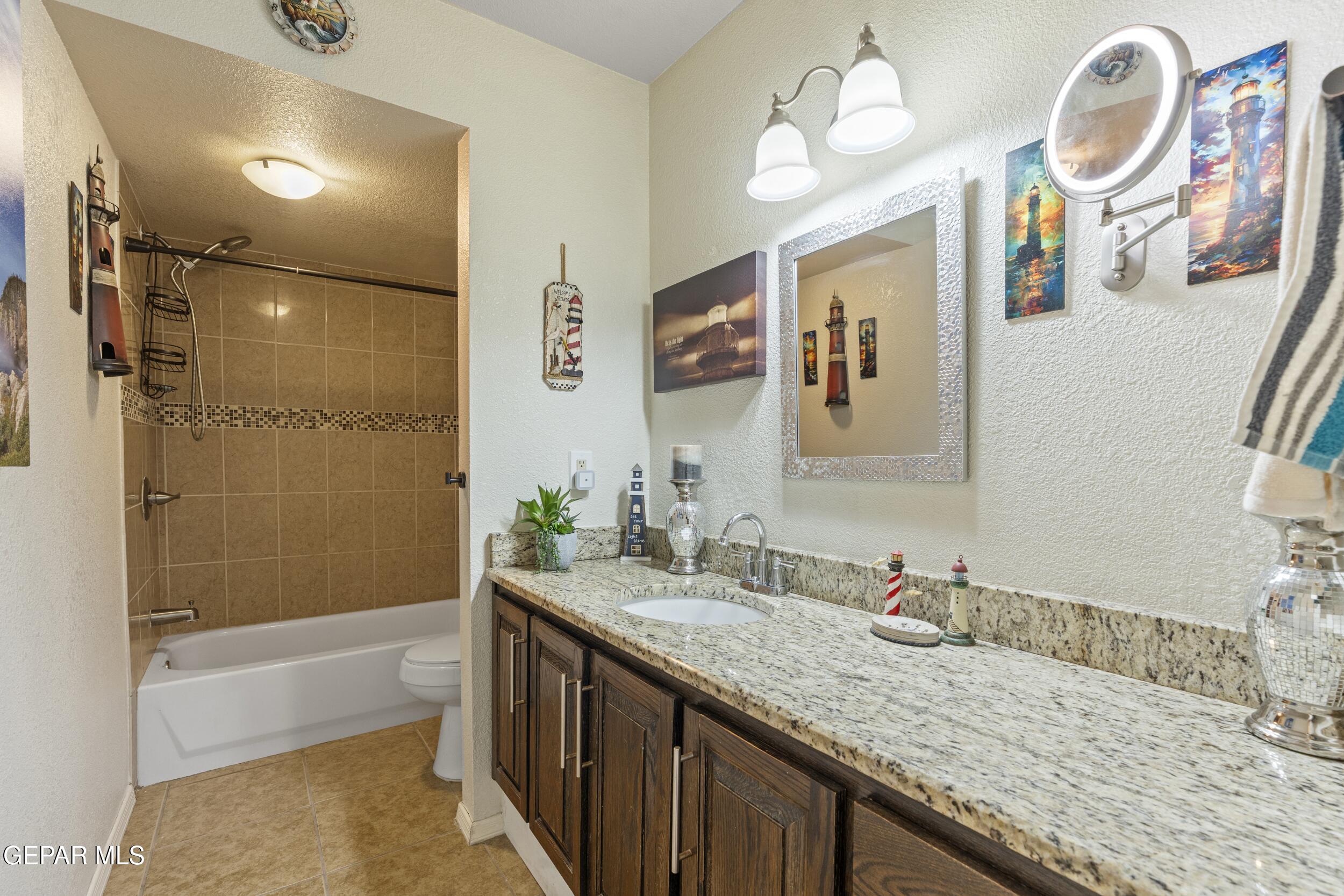 4433 North Stanton Street, Unit P358 El Paso, TX 79912 - Photo 7 of 19 a bathroom with a granite countertop sink mirror and a bath tub