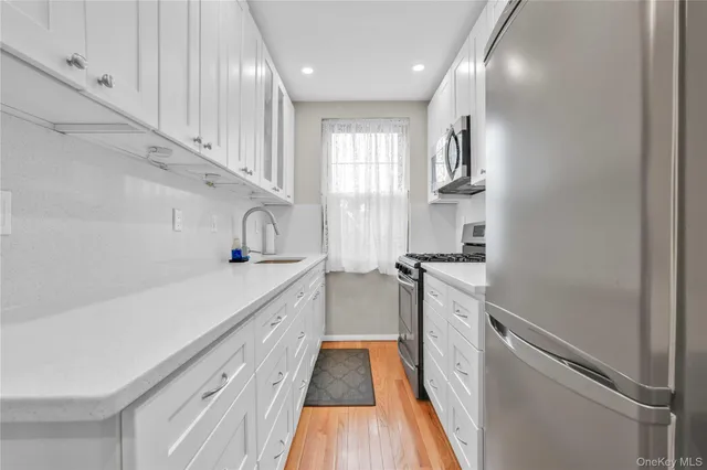 a kitchen with cabinets and wooden floor