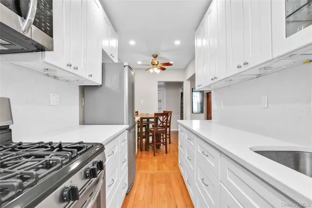 a kitchen with a stove and a wooden floor