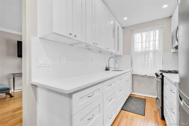 a kitchen with white cabinets and sink