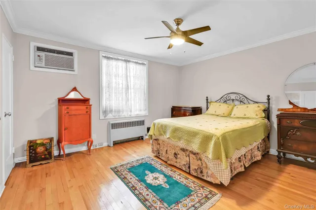 a bedroom with a bed a dresser and potted plants