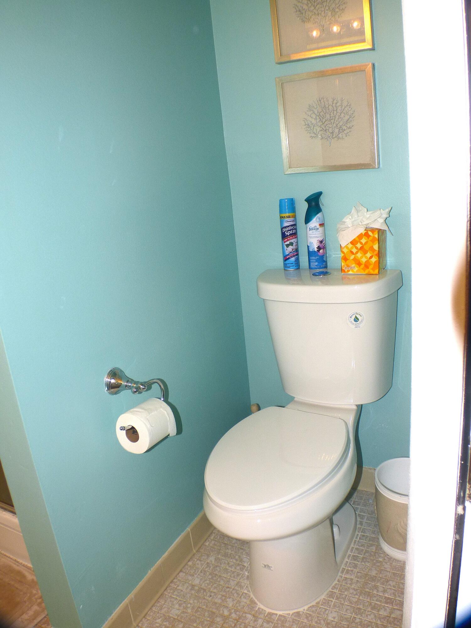 2686 Northwest 7th Court, Unit C Delray Beach, FL 33445 - Photo 12 of 33 a white toilet sitting next to a bathroom sink and vanity