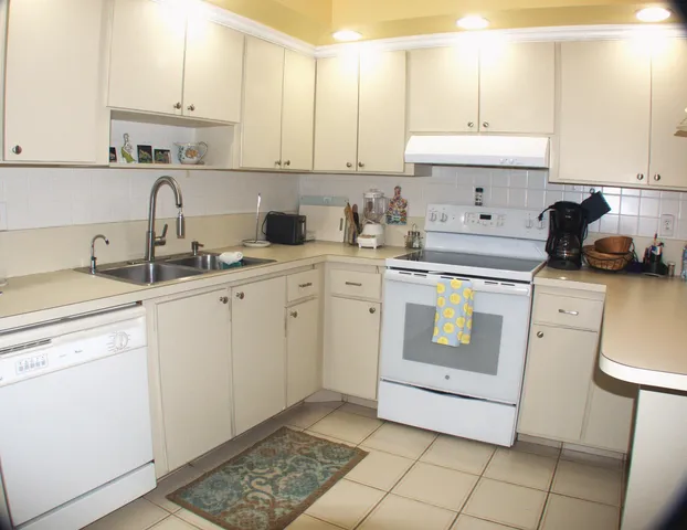 a kitchen with a sink a stove and cabinets