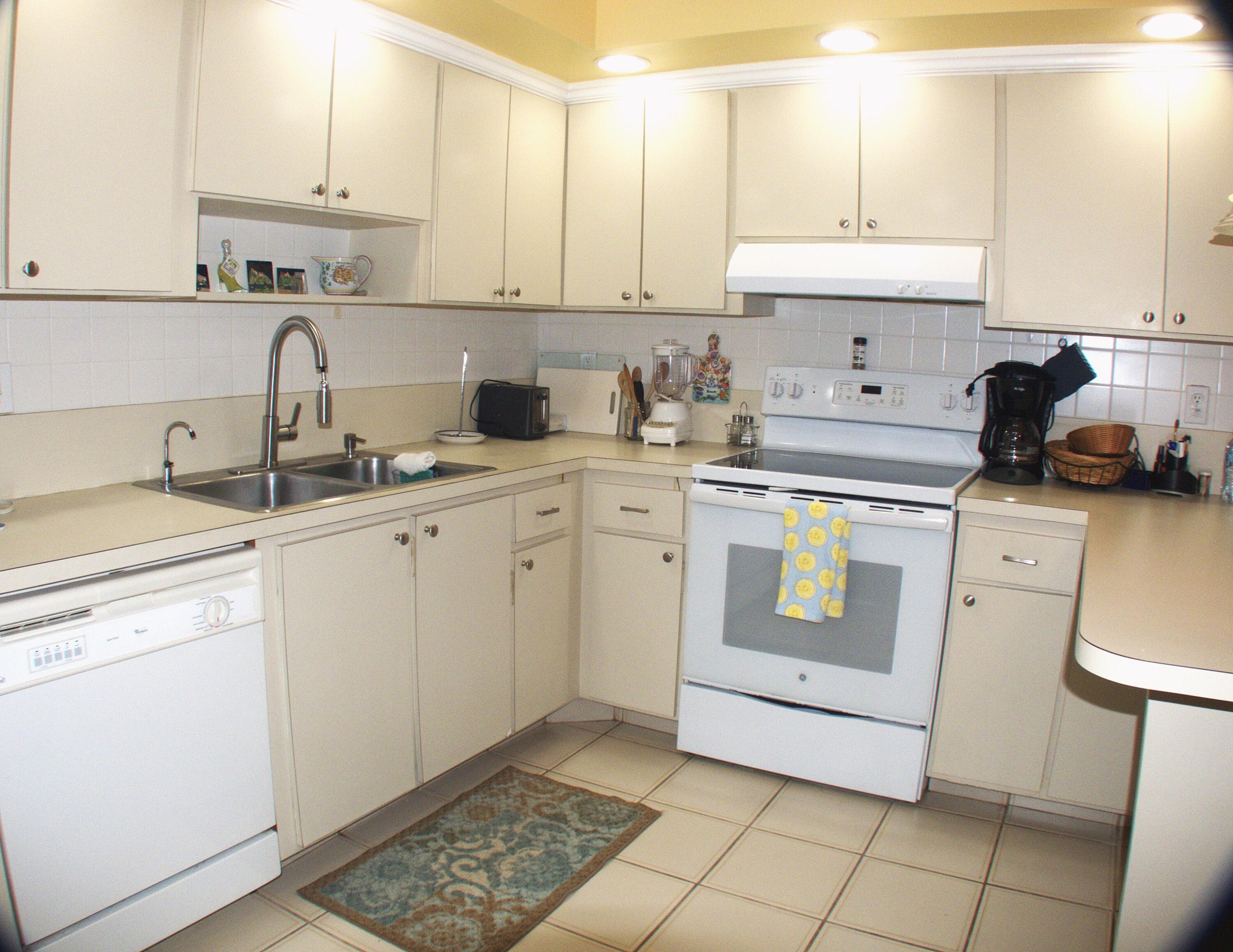 2686 Northwest 7th Court, Unit C Delray Beach, FL 33445 - Photo 4 of 33 a kitchen with a sink a stove and cabinets