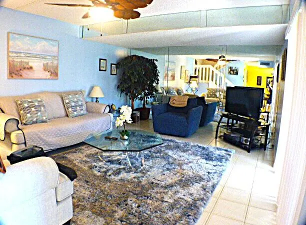 a living room with furniture and a dining table with wooden floor