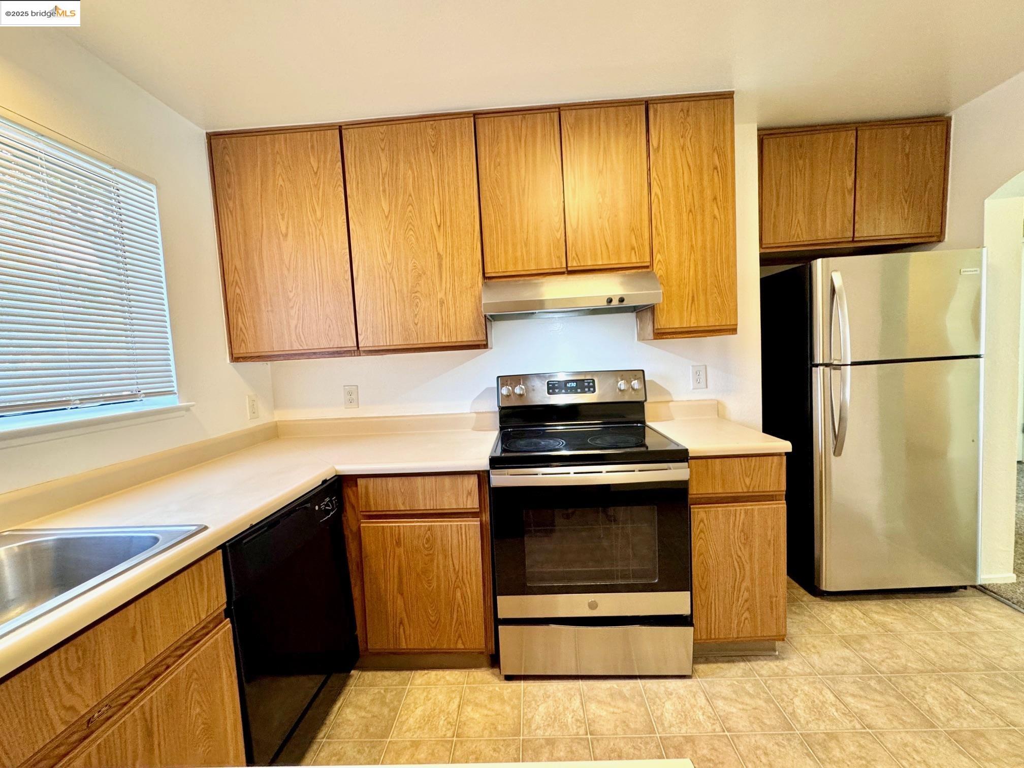 554 Bancroft Avenue, Unit 101 San Leandro, CA 94577 - Photo 2 of 17 a kitchen with a refrigerator sink and cabinets