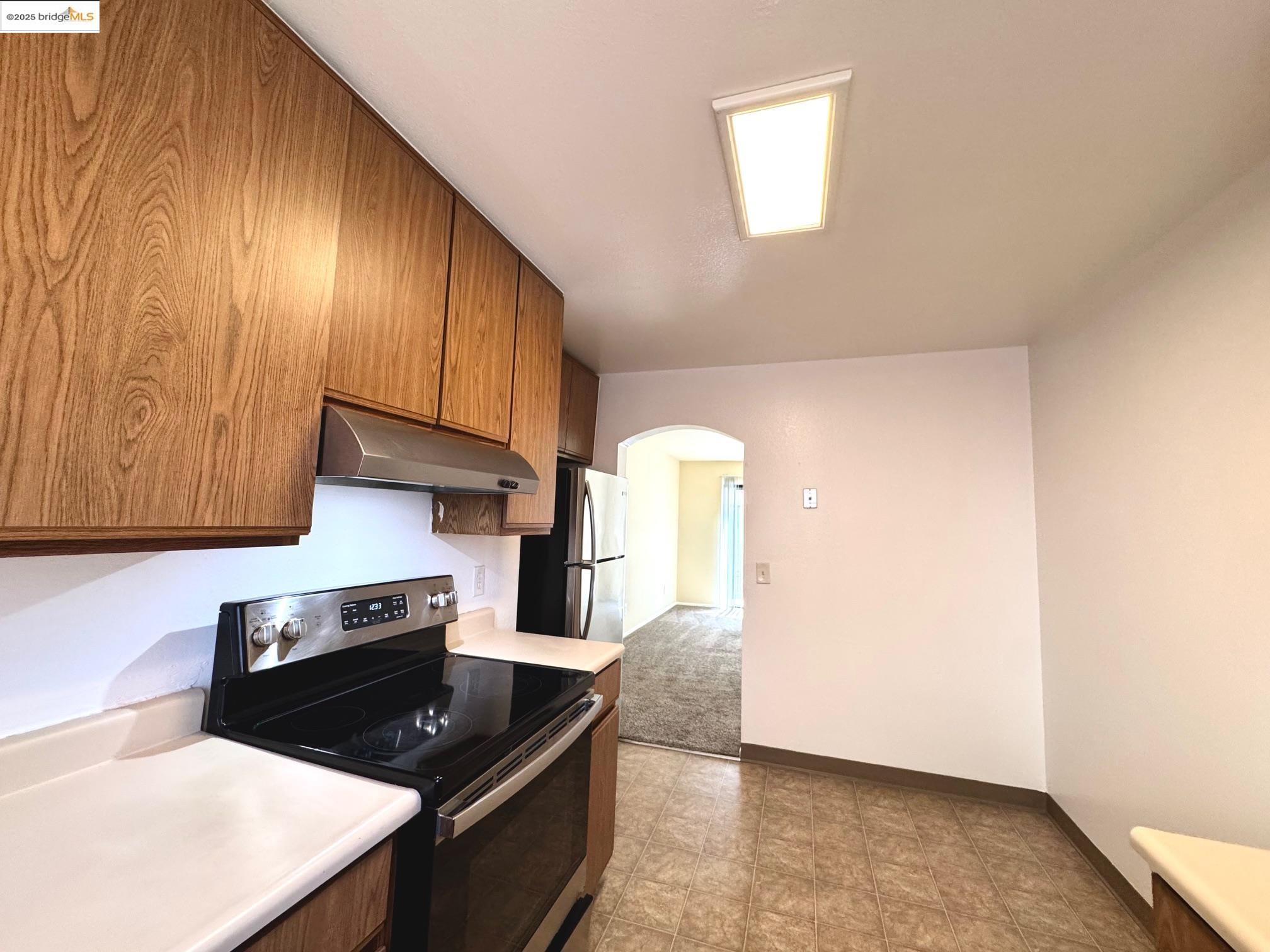 554 Bancroft Avenue, Unit 101 San Leandro, CA 94577 - Photo 3 of 17 a kitchen with granite countertop a stove a sink and a microwave