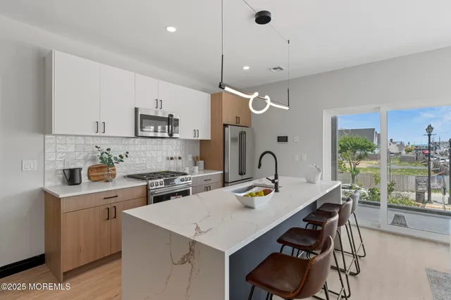 a kitchen with a stove and a white wooden cabinets