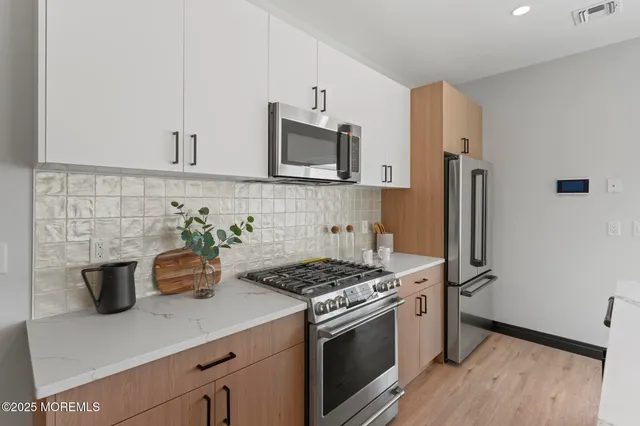 a kitchen with a sink a counter top space and living room view