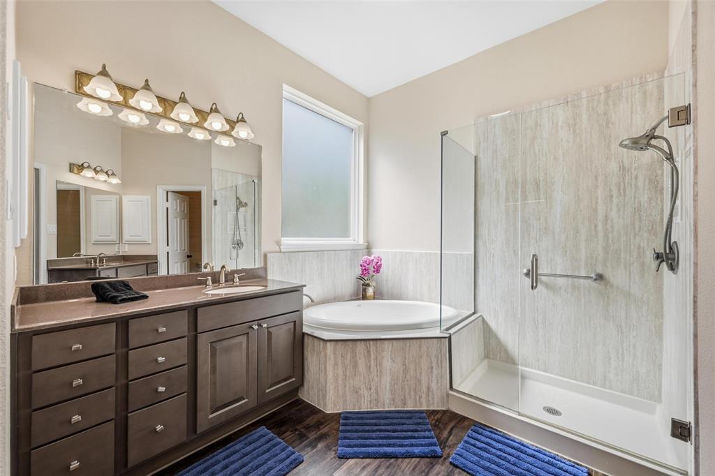 9305 Anns Way Plano, TX 75025 - Photo 16 of 39 Full bathroom with a stall shower, vanity, a bath, and dark wood-style floors