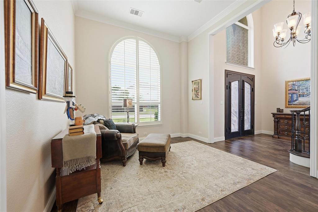 9305 Anns Way Plano, TX 75025 - Photo 18 of 39 Sitting room with dark wood-style flooring, a chandelier, crown molding, and a towering ceiling