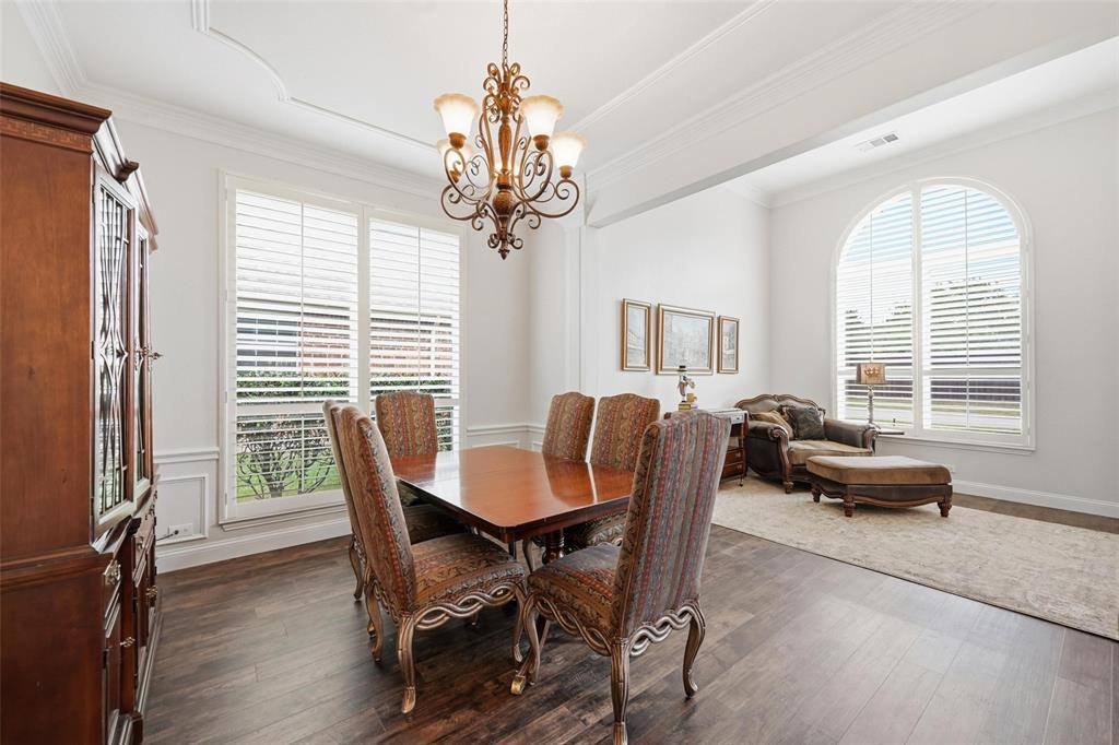 9305 Anns Way Plano, TX 75025 - Photo 19 of 39 Dining area featuring crown molding, dark wood-style flooring, and a chandelier