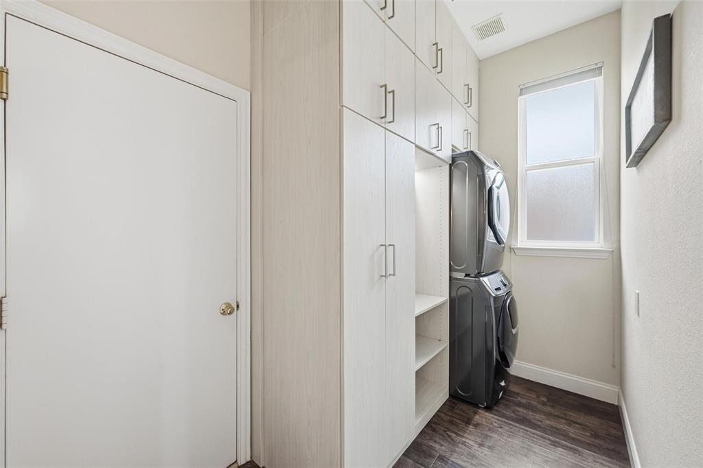 9305 Anns Way Plano, TX 75025 - Photo 31 of 39 Laundry area with stacked washing machine and dryer and dark wood-style flooring