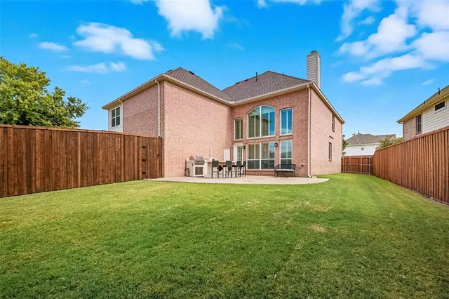 a view of a house with backyard and a tree