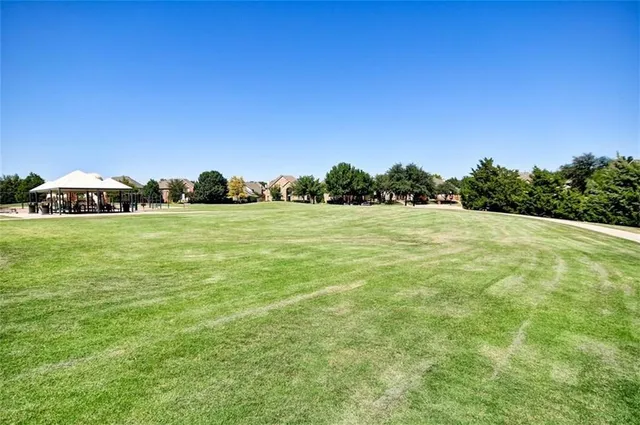 a view of a field with an trees in the background