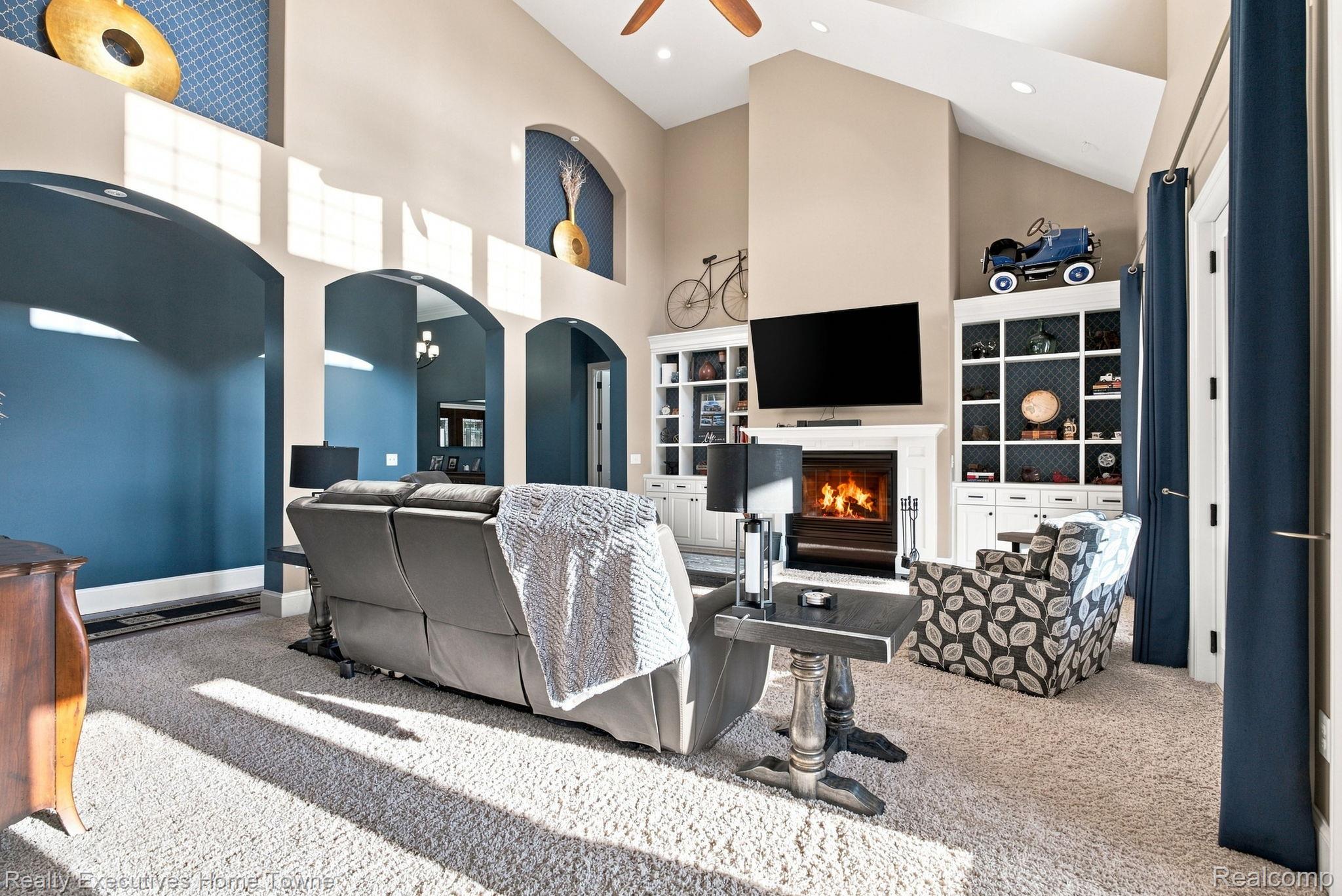 2829 Riverside Drive Port Huron, MI 48060 - Photo 26 of 99 Vaulted ceiling, arched doorways, built-in shelving, wood-burning fireplace with mantel, and carpet flooring