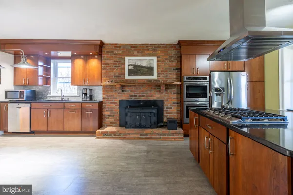 a kitchen with stainless steel appliances granite countertop a refrigerator and a sink