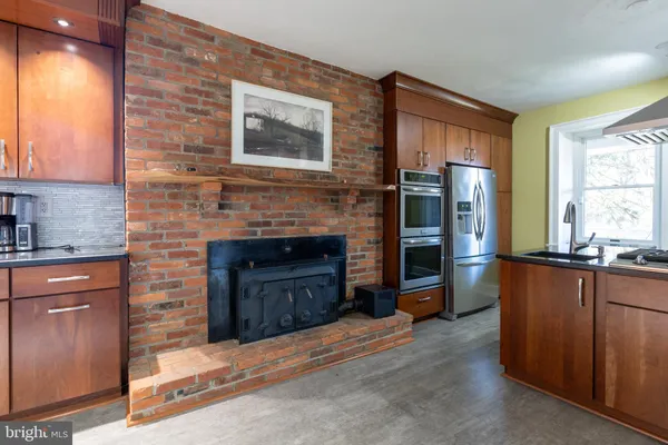 a kitchen with kitchen island granite countertop wooden cabinets and a sink