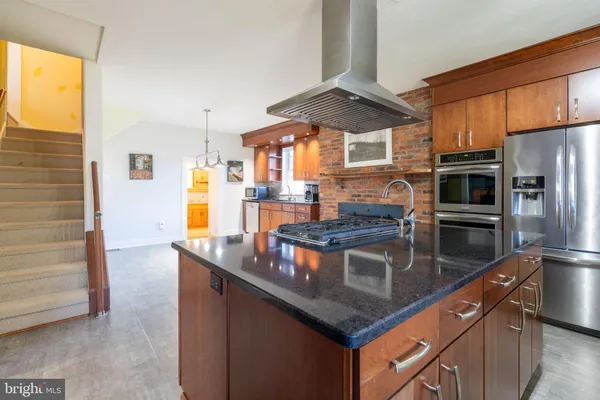 a kitchen with stainless steel appliances granite countertop a stove a sink and a refrigerator