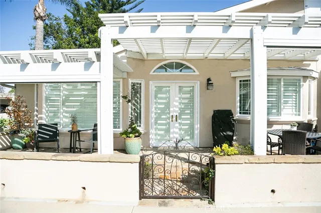 a view of a patio with table and chairs potted plants and floor to ceiling window