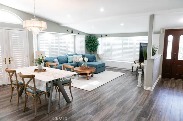 a living room with furniture dining table and a large window