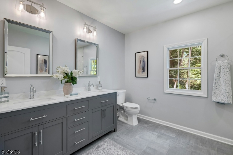 26 Woodland Road Morristown, NJ 07960 - Photo 13 of 26 a spacious bathroom with a double vanity sink a toilet and a mirror