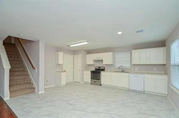 a open kitchen with white cabinets and stainless steel appliances