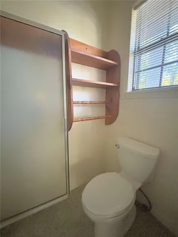 a bathroom with a toilet and a window