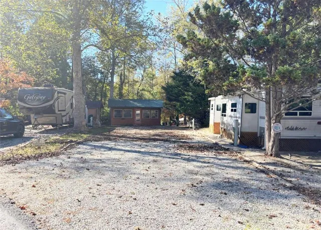 a view of a house with a yard and large tree