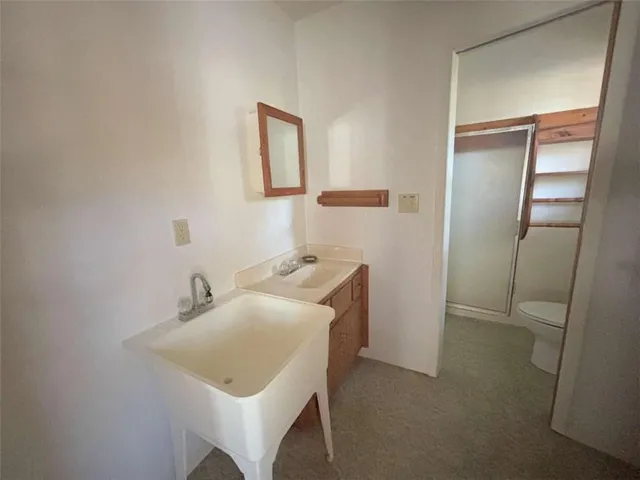 a bathroom with a sink toilet and mirror
