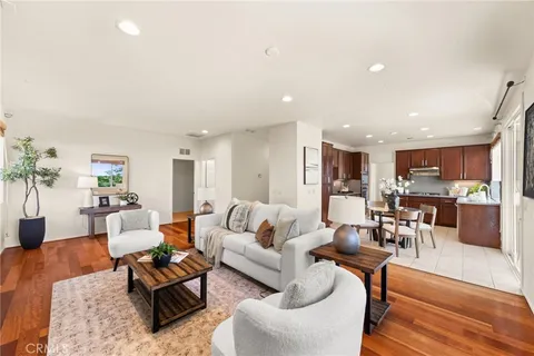 a living room with furniture and view of kitchen