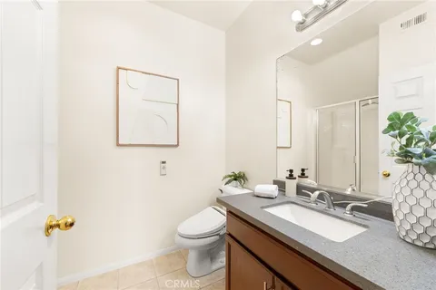 a bathroom with a granite countertop sink a toilet and mirror