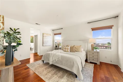 a bedroom with a large bed and a potted plant