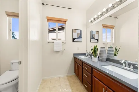 a bathroom with a granite countertop sink a toilet and mirror