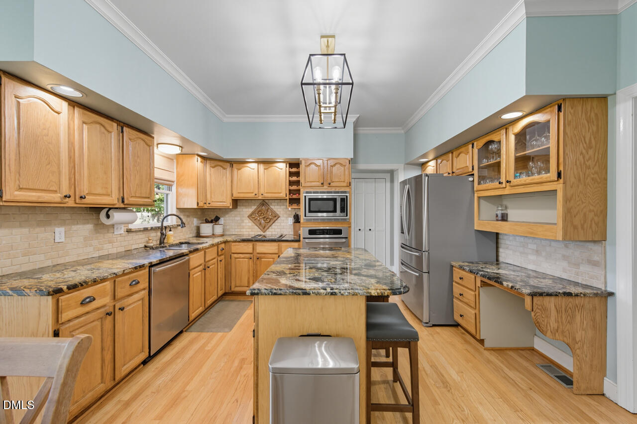 8713 Mourning Dove Road Raleigh, NC 27615 - Photo 14 of 56 a kitchen with stainless steel appliances granite countertop a sink refrigerator and cabinets
