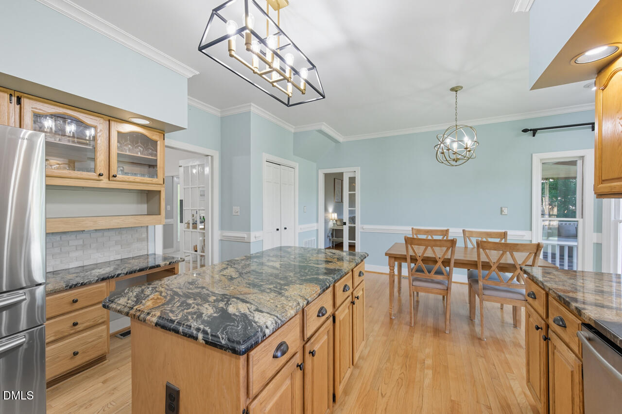 8713 Mourning Dove Road Raleigh, NC 27615 - Photo 17 of 56 a kitchen with a table chairs and wooden floor